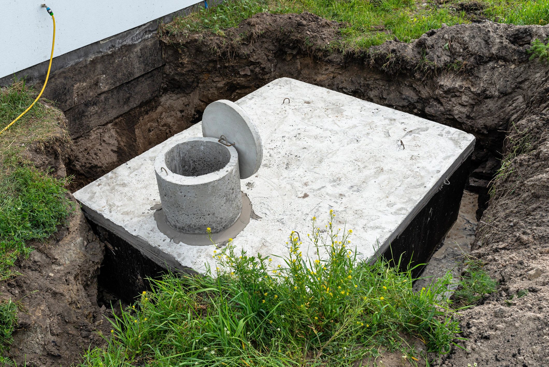Concrete septic tank being installed in an excavated yard in Illinois